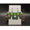 Cute machine embroidered earrings -elf legs and green boots with a green bow with a yellow buckle as the body. Black hypoallergenic hooks.